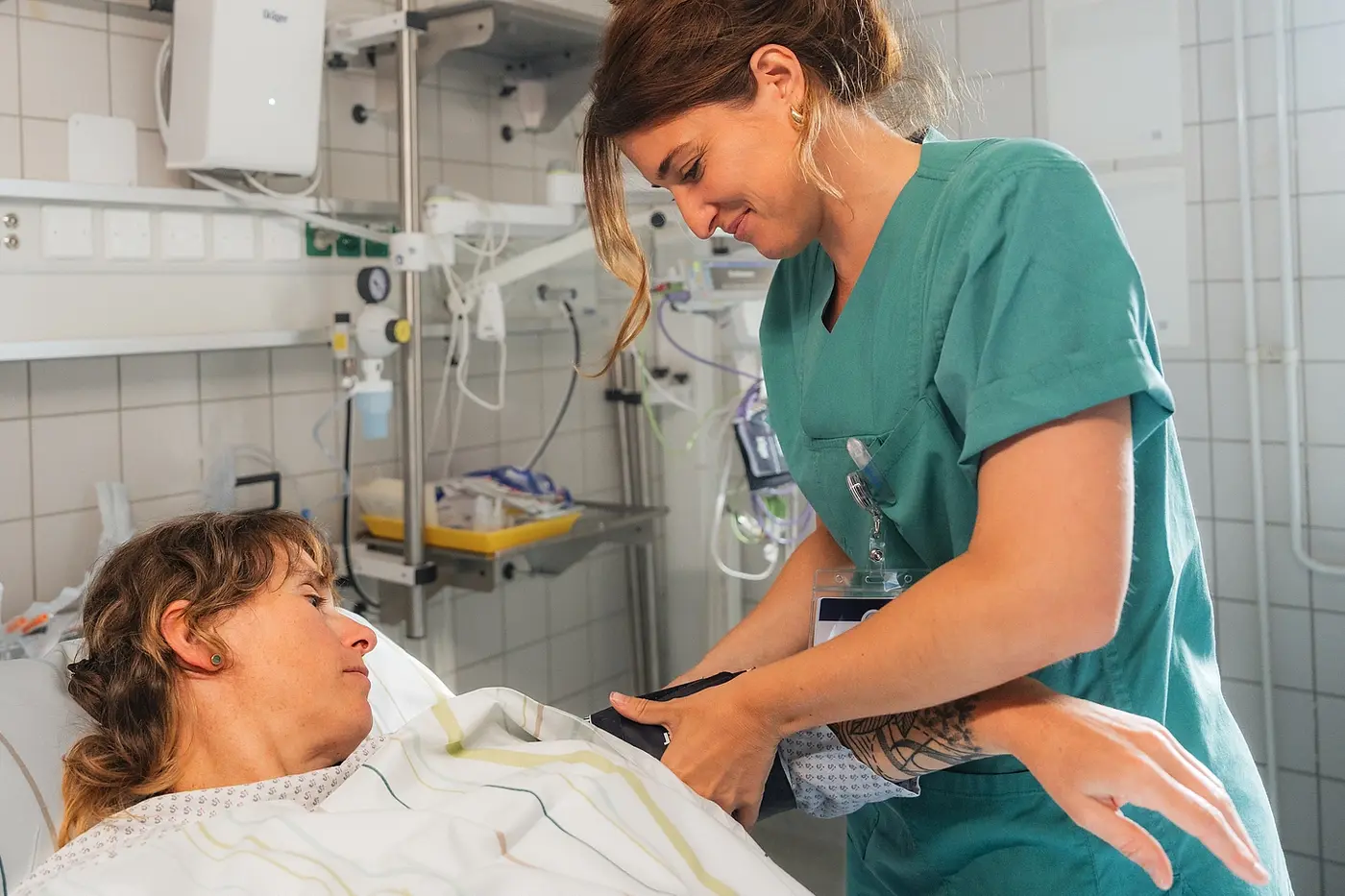 Pflegefachkraft misst den Blutdruck bei einer Patientin