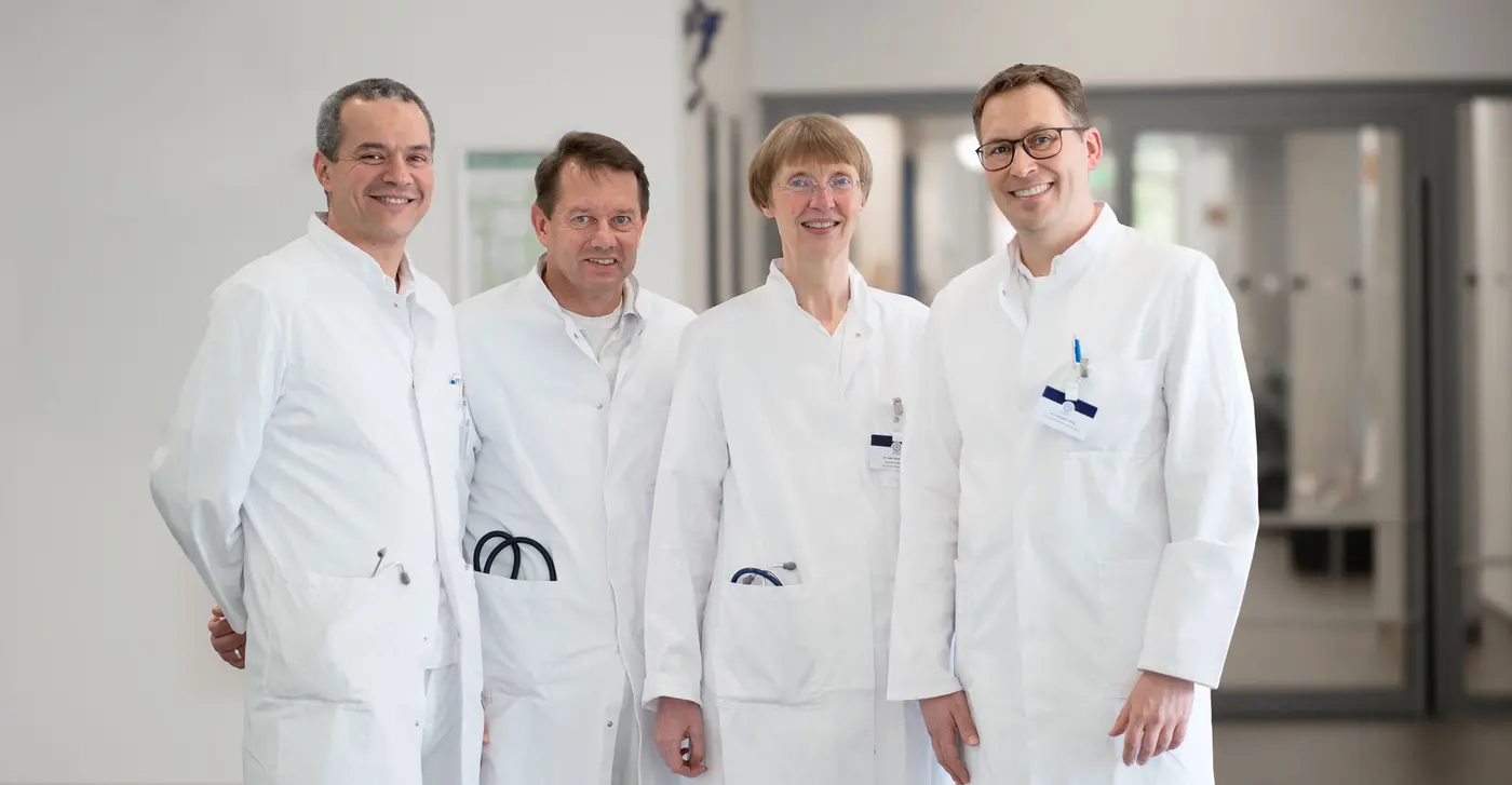 Ärzte Team im Krankenhaus Marienstift: Drei Ärzte und eine Ärztin in weißen Kitteln lachen in die Kamera