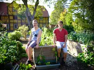Zwei junge Männer mit Behinderungen bei den Hochbeeten
