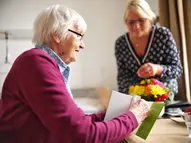 Fachkraft vom Begleitenden Dienst verbringt Zeit mit einer Bewohnerin