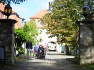 Blick auf den schönen Hof vom Rittergut Beienrode. Eine Gruppe Menschen geht spazieren